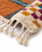 Terracotta Blocks Beni Ourain rug fringe detail on white studio background