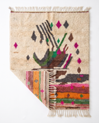 Atlas Bird Beni Ourain rug folded corner on white studio background
