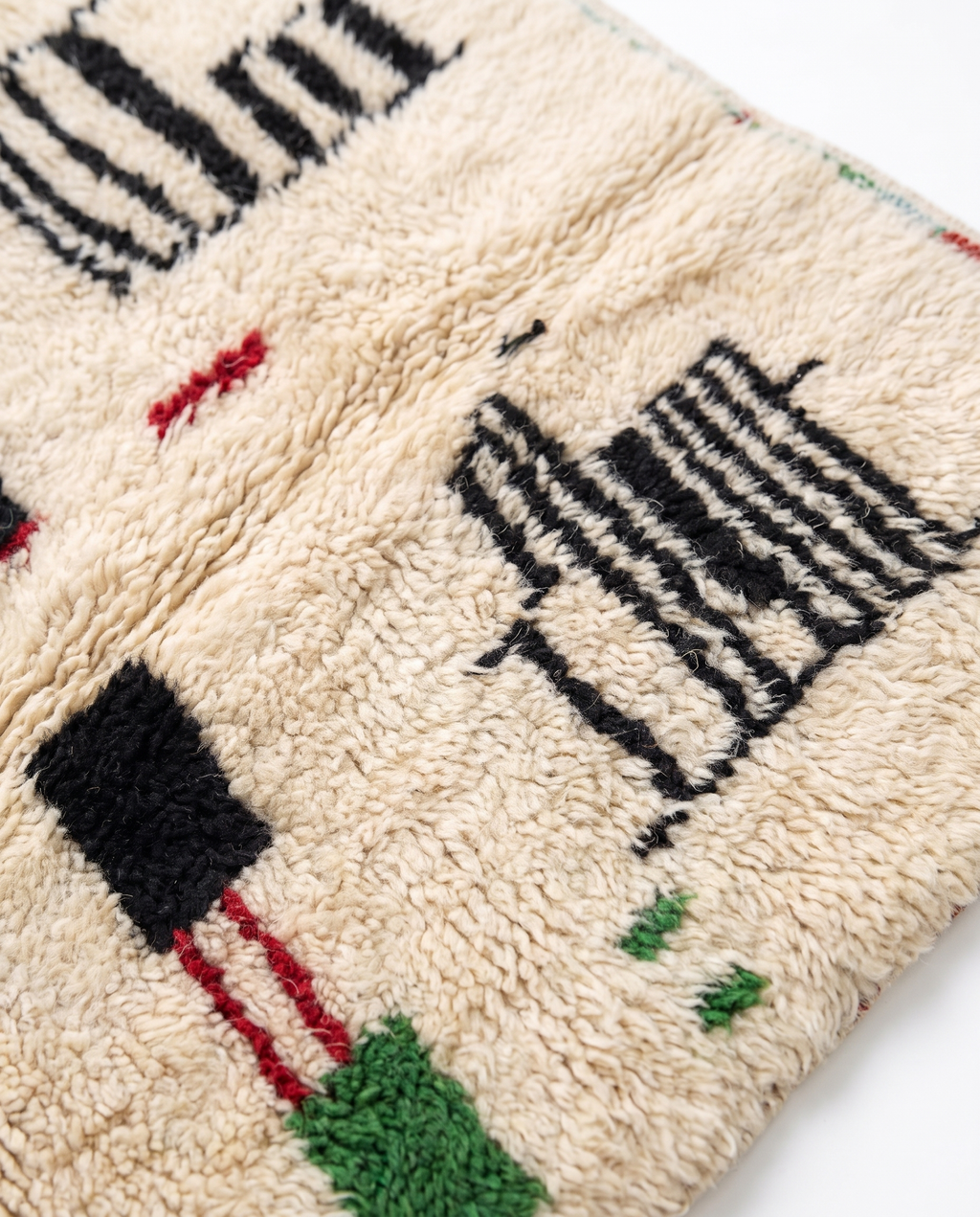 Village Signs Beni Ourain rug wool texture close-up on white studio background