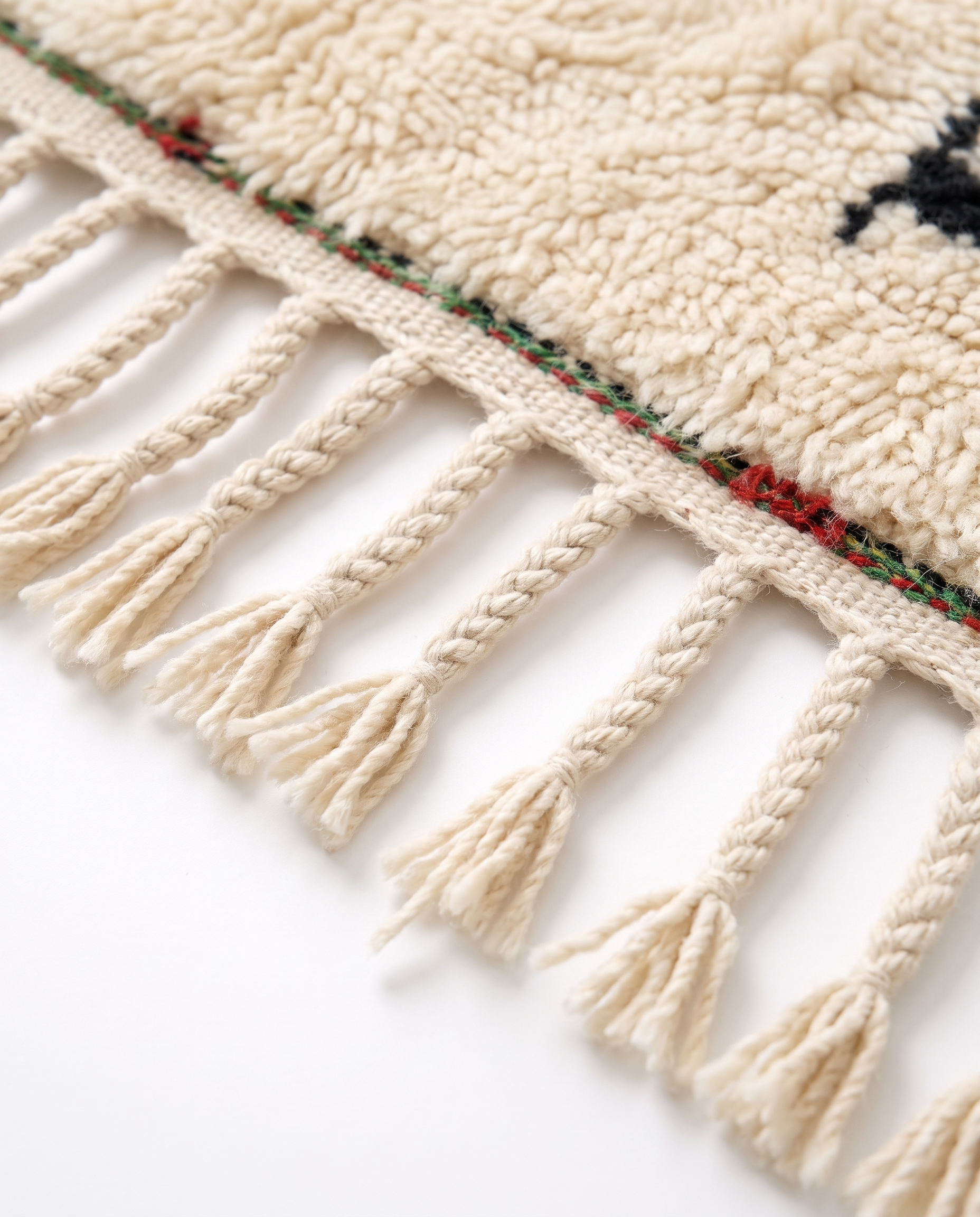 Village Signs Beni Ourain rug fringe detail on white studio background