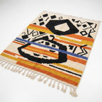 Saffron Jazz Azilal rug, handwoven wool with black, orange, yellow and blue motifs and stripes, flat lay top view