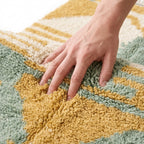 Sage & Ochre Mrirt rug — hand resting on the soft wool pile
