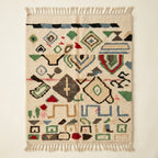 Wild Symbols Azilal rug, handwoven wool with green, rust, blue and red abstract symbols, flat lay top view
