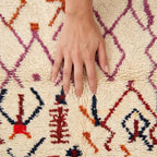 Zigzag Fiesta Azilal rug — hand resting on the soft wool pile